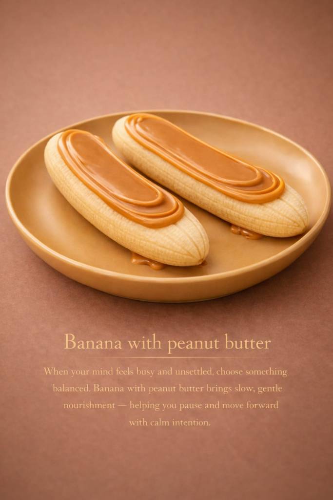 Two peeled bananas topped with peanut butter on a round plate, placed against a warm brown background.